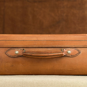 Close up of the handle of the leather case, circa 1925. Brown and cream background.