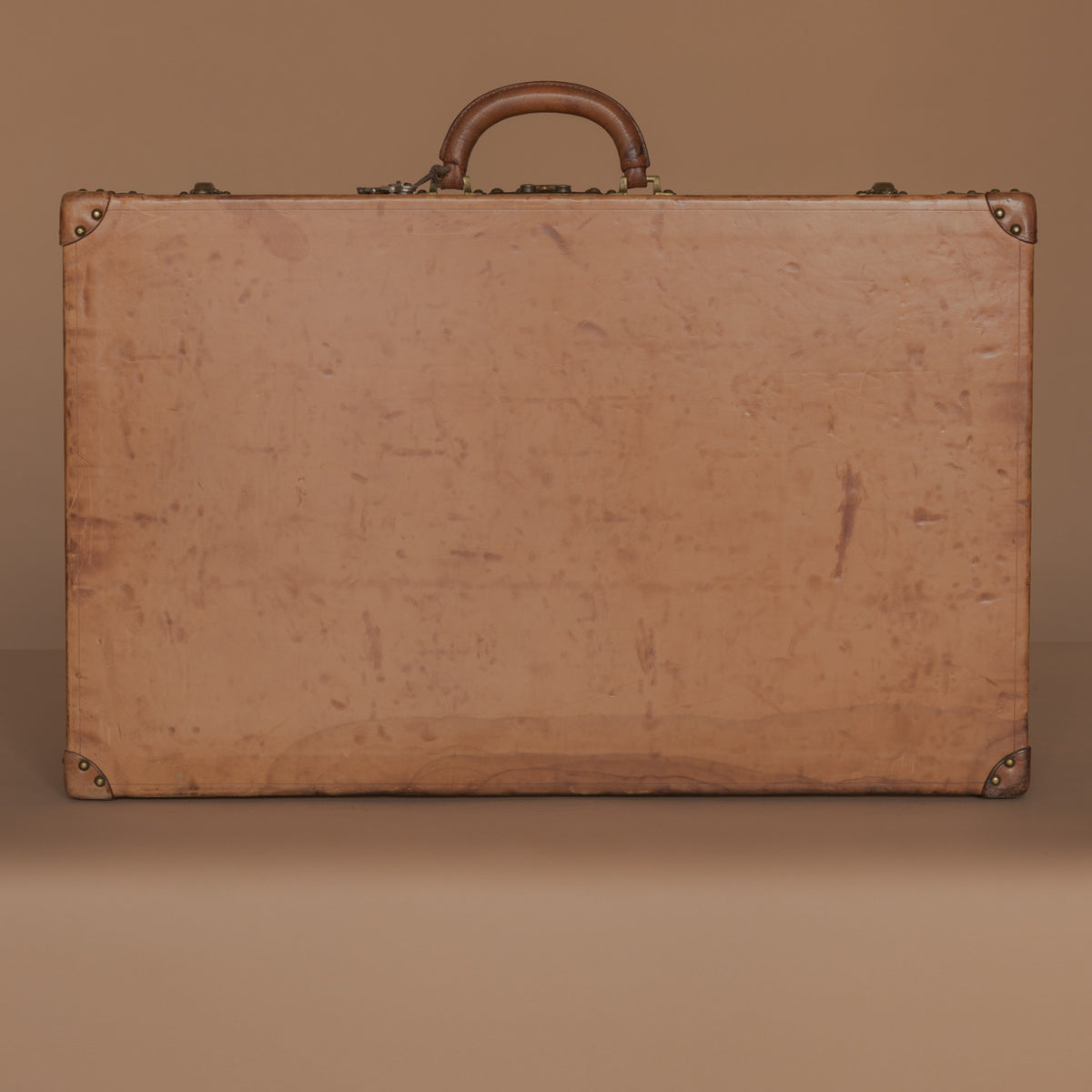 LOUIS VUITTON, a brown faux leather suitcase from around 1910. - Bukowskis