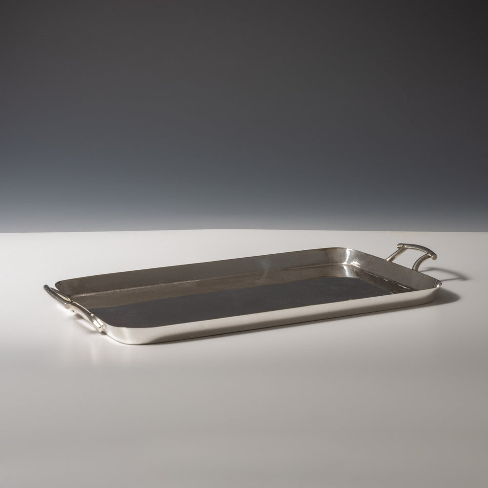 Walker and Hall silver plated rectangular tray with raised edges viewed from the side with a handle each end. White and grey set at a diagonal.