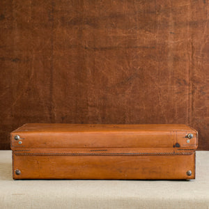Rear view, showing the stitching of the hinge of the English leather case, circa 1925. Brown and cream background.