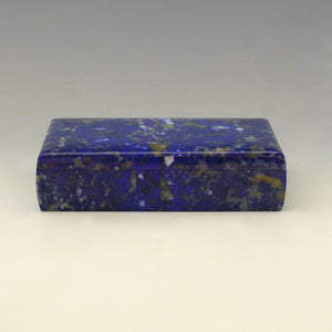A front view of a Lapis Lazuli box with a cobalt blue base colour and white, beige and dark blue mottling running through the stone. white background.